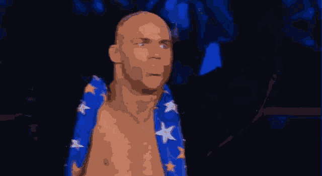 a man with a blue and white scarf around his neck is standing in a dark room