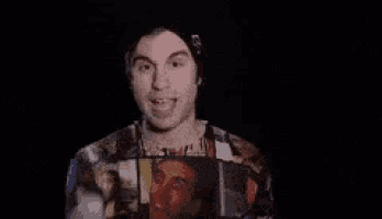 a man in a hat and a colorful shirt is making a funny face .