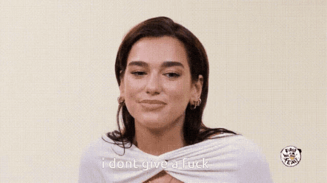 a woman in a white top is smiling and says i dont give a fuck