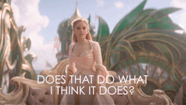 a woman in a pink dress sits on a couch with the words " does that do what i think it does " above her