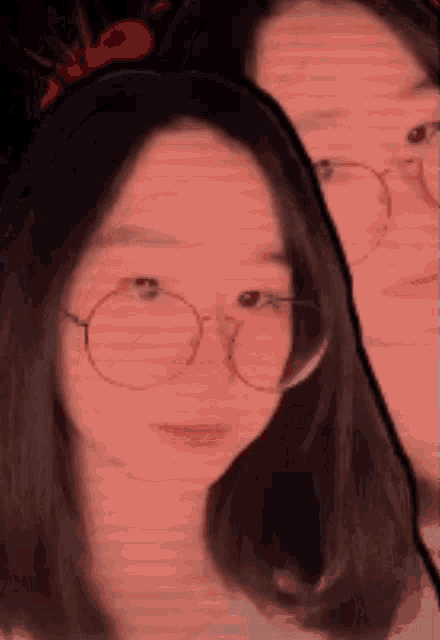 a woman wearing glasses and a headband with a red flower on it