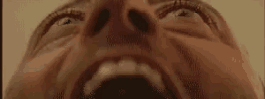 a close up of a man 's face with his mouth open and his eyes open .