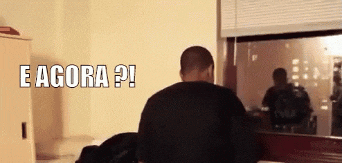 a man in a black shirt is standing in front of a window with the words e agora ?