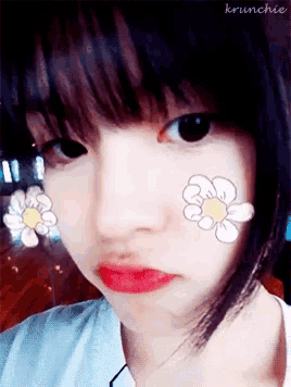 a girl with flowers painted on her face has krunchie written on the bottom left
