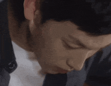 a close up of a man 's face and neck with his eyes closed .