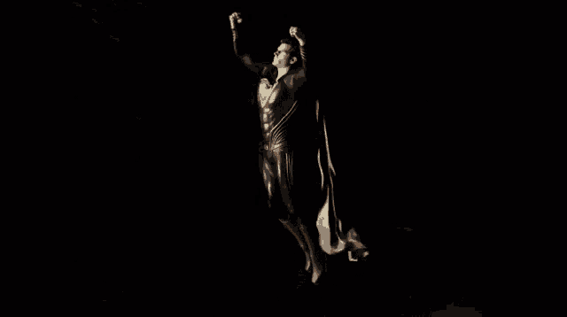 a man in a cape is flying over the earth in the dark .