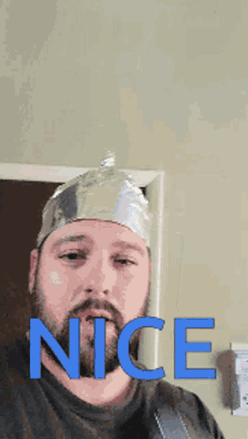 a man wearing a tin foil hat is holding a megaphone with the word nice written on it