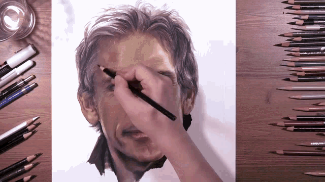 a person is drawing a man 's face with a pencil on a piece of paper