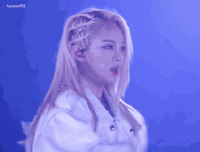 a woman with a braid in her hair is wearing a white jacket and ear buds