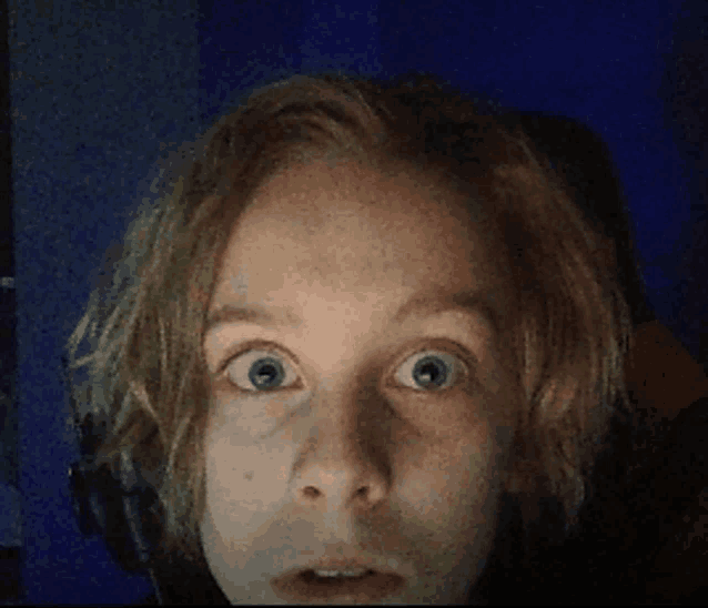 a close up of a person 's face with a surprised look on her face