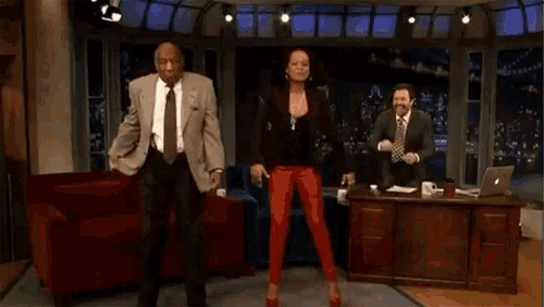 a man and two women are dancing in a studio