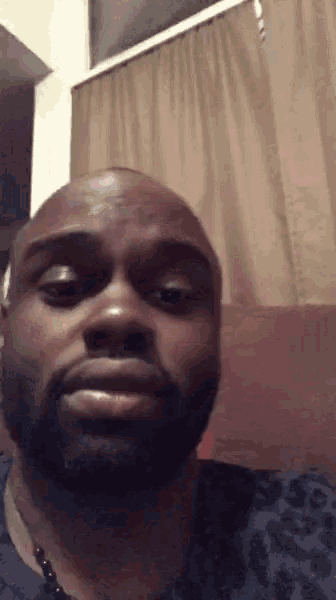 a man with a beard looks at the camera with a serious look on his face