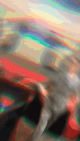 a blurry picture of a person 's face with a rainbow background