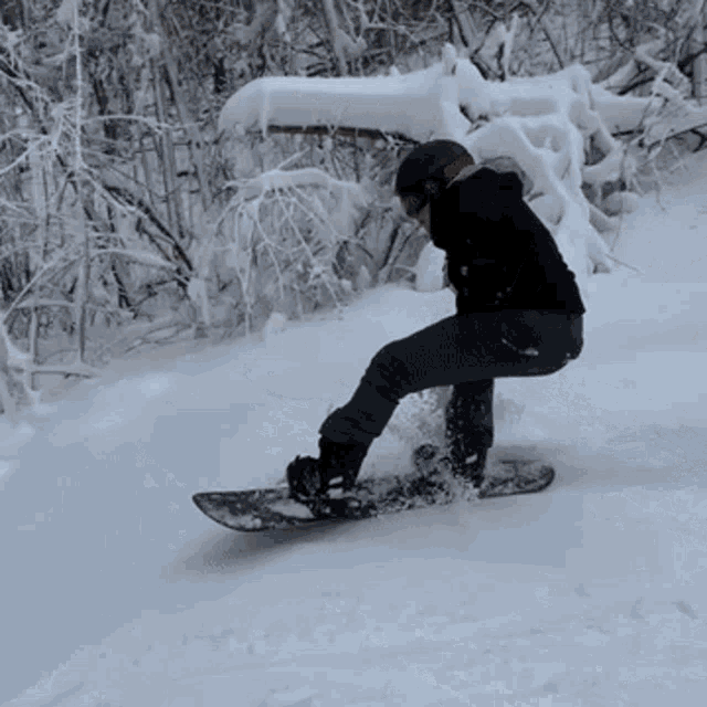a person riding a snowboard down a snow covered hill
