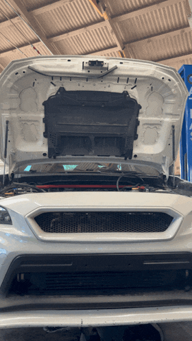 a white car with the hood open and the letters i on the hood