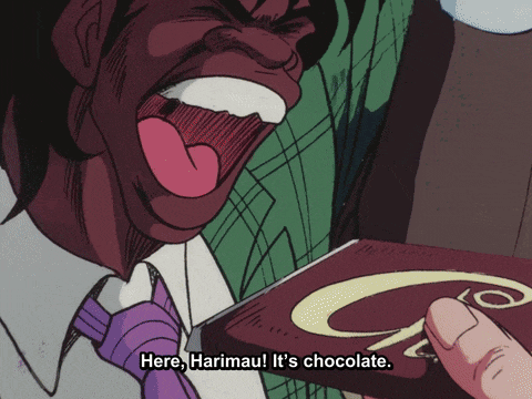 a man in a purple tie is holding a box of chocolate and yelling " here harimau it 's chocolate "