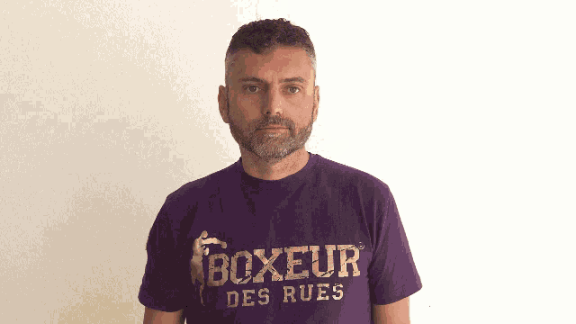 a man wearing a purple boxeur des rues t-shirt