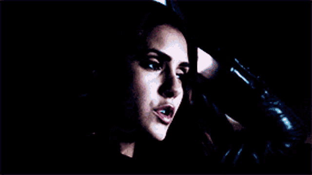 a close up of a woman 's face while driving a car