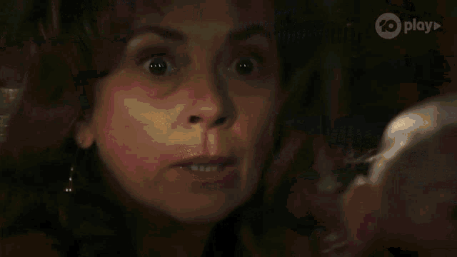 a close up of a woman 's face with a play logo on the bottom