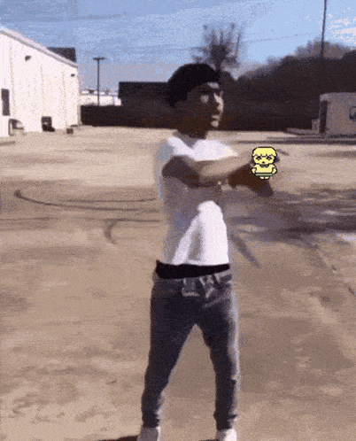 a man in a white shirt and blue jeans is standing in a parking lot
