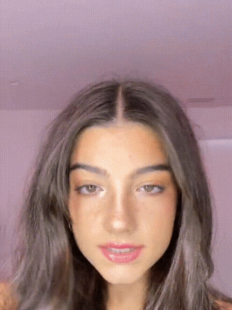 a close up of a young woman 's face with a pink background