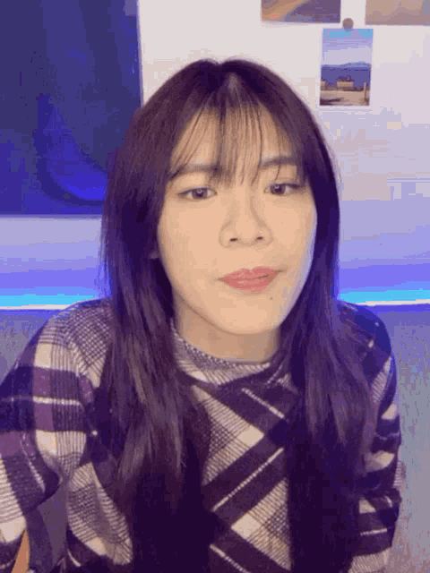a girl with long hair and bangs looks at the camera
