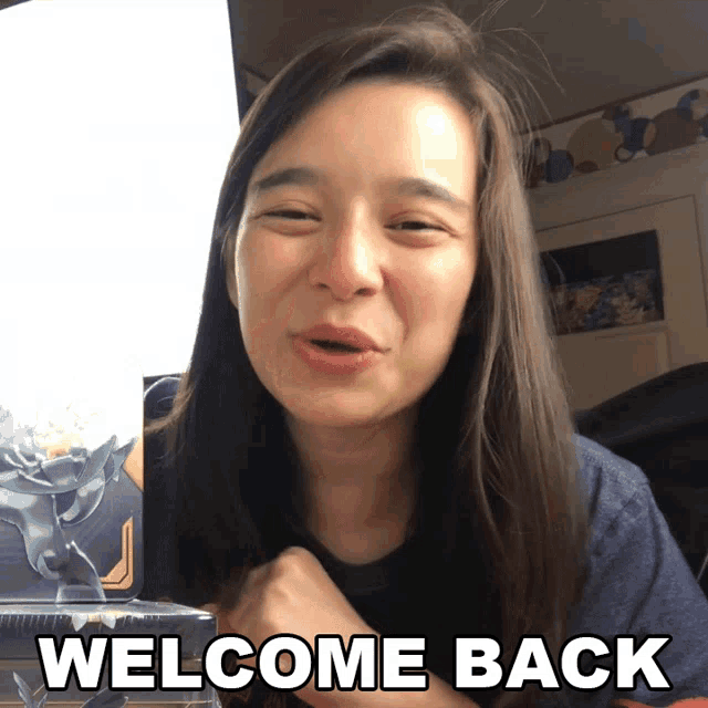 a woman says welcome back while holding a box
