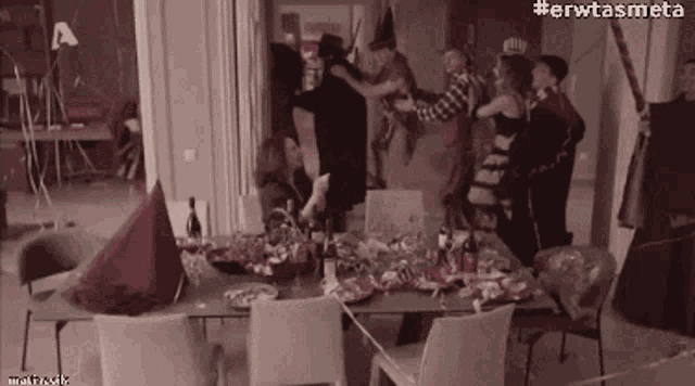 a group of people are having a party in a room with a table and chairs covered in decorations .