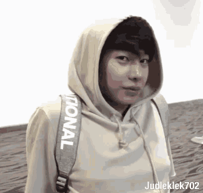 a young man wearing a hoodie and carrying a backpack