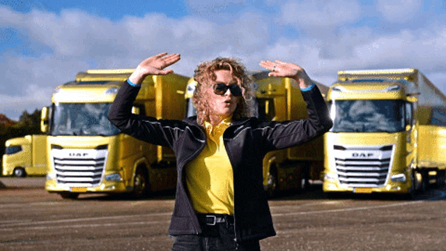 a woman in a yellow shirt is standing in front of a daf truck