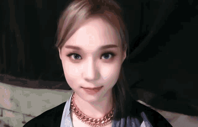 a close up of a woman wearing a necklace and ponytail