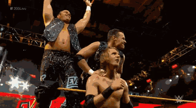 a group of wrestlers are standing in a ring with the letters w on the bottom