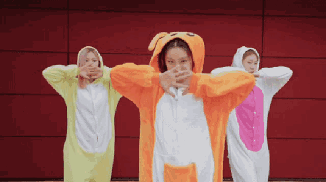 three girls wearing animal costumes are dancing together