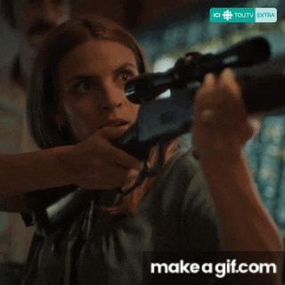 a woman is holding a rifle with a make a gif.com watermark