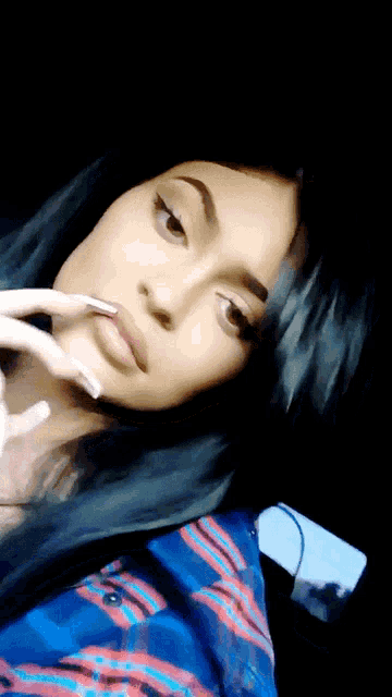 a close up of a woman 's face with a blue shirt on