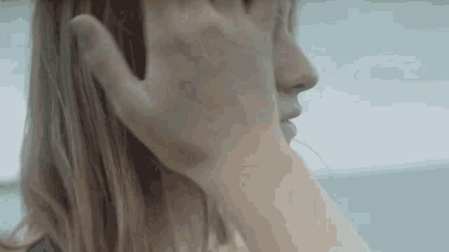 a close up of a person touching a woman 's face with their hand