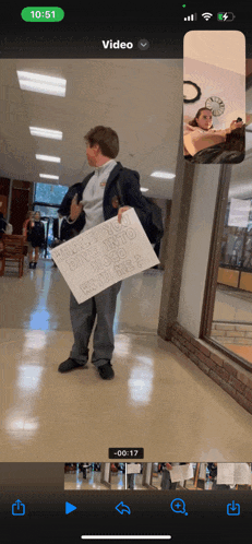 a phone screen shows a man holding a sign that says " why you don t try to hook with me "