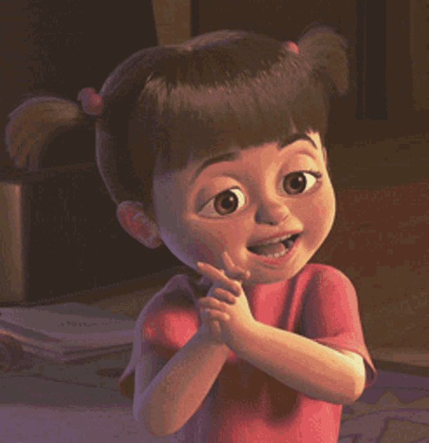 a little girl in a red shirt is smiling and clapping