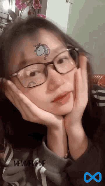 a girl with glasses and a unicorn tattoo on her face