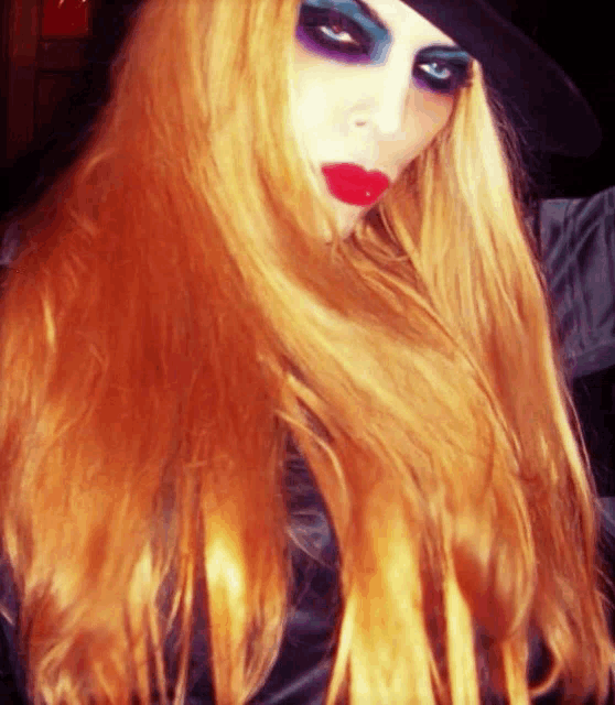 a woman with long red hair is wearing a black top hat