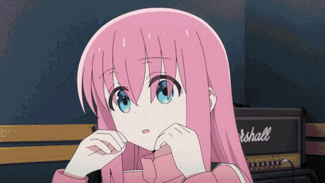 a girl with pink hair is sitting in front of a marshall amp