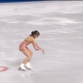 a woman in a pink dress is ice skating in front of an advertisement for decoste