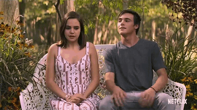 a man and a woman are sitting on a bench with a netflix logo in the corner