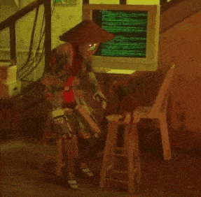 a person sitting on a stool in front of a computer monitor