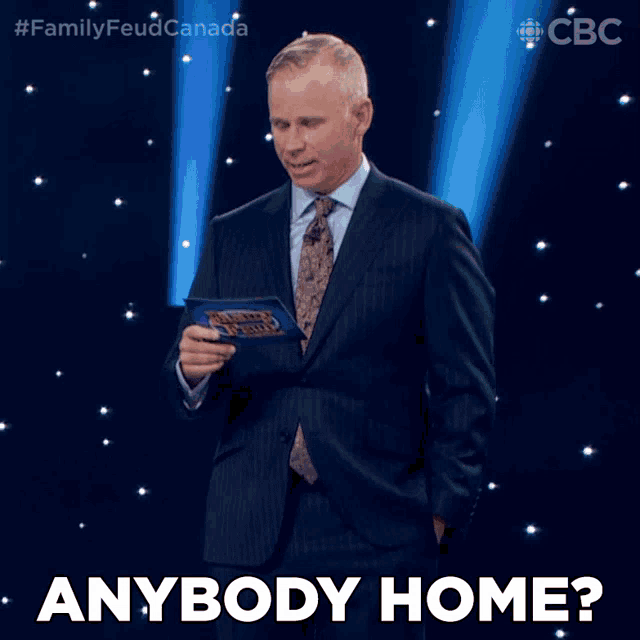 a man in a suit and tie is holding a binder that says family feud canada