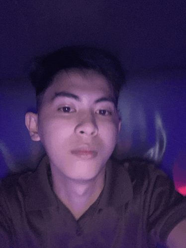 a young man is taking a selfie in front of a purple background