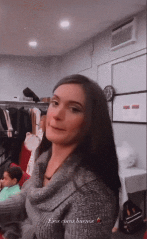 a woman wearing a grey sweater says esos carros buenos on the bottom