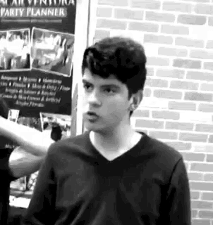a young man stands in front of a poster that says party planner