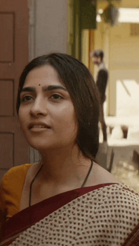 a woman with a bindi on her forehead is wearing a saree
