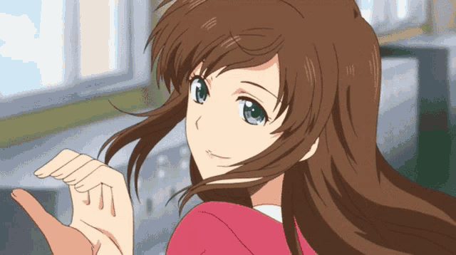 a girl with long brown hair and green eyes is giving a thumbs up